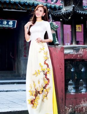 Áo dài nữ trắng vẽ hoa mai vàng nổi bật